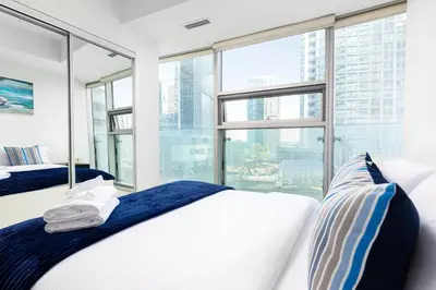 a bedroom with two beds and a large window at 2 bedrooms Downtown Toronto Free parking in Toronto