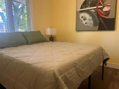 a bed in a bedroom with a painting on the wall at Cozy Home Away From Home in Kitchener