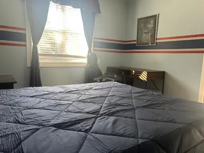 a bedroom with a bed and a desk and a window at Cozy Home Away From Home in Kitchener