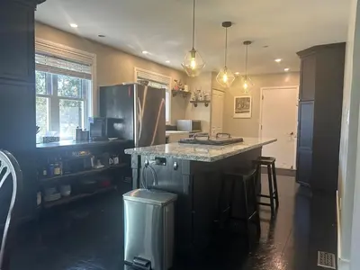 a kitchen with a counter and a island with stools at Cozy Home Away From Home in Kitchener
