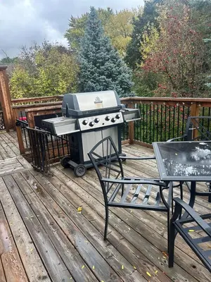a grill sitting on a deck with a table at Cozy Home Away From Home in Kitchener