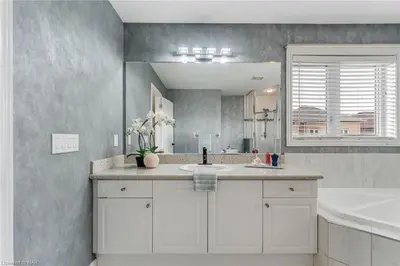 a bathroom with a sink and a large mirror at Tranquil Haven near Niagara in Thorold