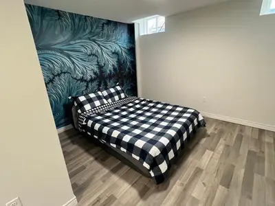 a bedroom with a checkered bed in a room at Tranquil Haven near Niagara in Thorold