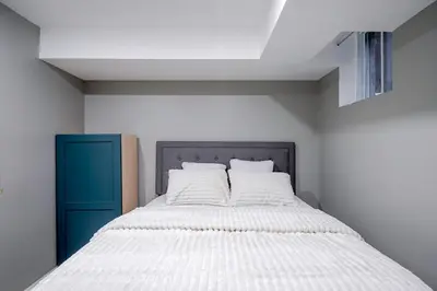 a bedroom with a bed and a blue cabinet at Renovated 2 Bedroom Basement Apartment Near 401 and Amenities in Bowmanville