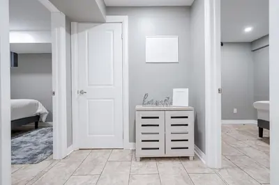 a bedroom with a white door and a white dresser at Renovated 2 Bedroom Basement Apartment Near 401 and Amenities in Bowmanville