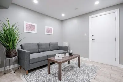a living room with a couch and a table at Renovated 2 Bedroom Basement Apartment Near 401 and Amenities in Bowmanville