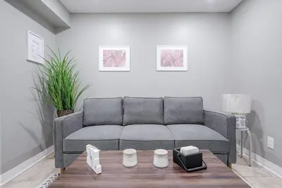 a living room with a couch and a table at Renovated 2 Bedroom Basement Apartment Near 401 and Amenities in Bowmanville