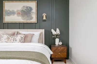 a bedroom with a bed and a painting on the wall at Stylish and Cozy Muskoka Vacation Home in Gravenhurst