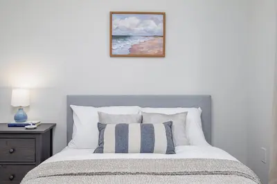 a bedroom with a bed with a picture on the wall at Stylish and Cozy Muskoka Vacation Home in Gravenhurst