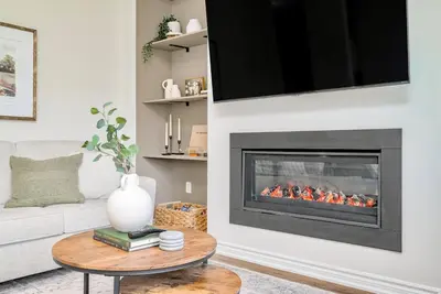 a living room with a fireplace with a tv at Stylish and Cozy Muskoka Vacation Home in Gravenhurst