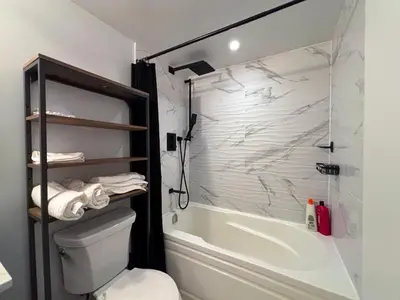 a bathroom with a shower and a toilet and a tub at DT Cozy 1B1B with Den near UofT and Bay St in Toronto