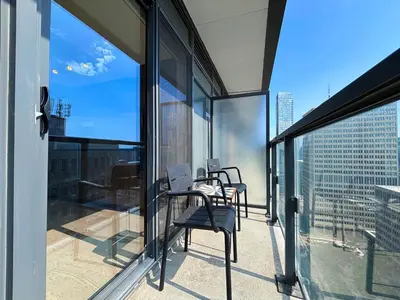 a balcony with chairs and a table on top of a building at DT Cozy 1B1B with Den near UofT and Bay St in Toronto