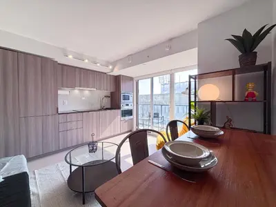a kitchen and dining room with a wooden table at DT Cozy 1B1B with Den near UofT and Bay St in Toronto