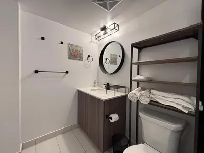 a bathroom with a sink and a mirror and a toilet at DT Cozy 1B1B with Den near UofT and Bay St in Toronto
