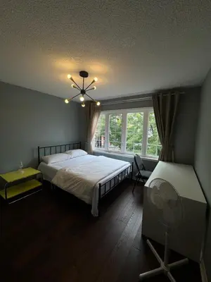 a bedroom with a bed and a window and a fan at Gorgeous Private room in Toronto