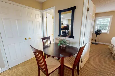 a dining room with a table and chairs and a mirror at Condo 701 at North Creek Resort in Blue Mountains