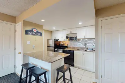 a kitchen with a counter and stools in a room at Condo 701 at North Creek Resort in Blue Mountains