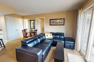 a living room with a leather couch and a table at Condo 701 at North Creek Resort in Blue Mountains
