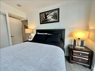 a bedroom with a large bed and two lamps at Spacious two-bedroom abode in the heart of TO in Toronto