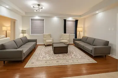 a living room with two couches and a table and chairs at Spacious Brampton 4BR Upper Home in Brampton