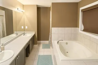 a bathroom with two sinks and a bath tub at Spacious Brampton 4BR Upper Home in Brampton
