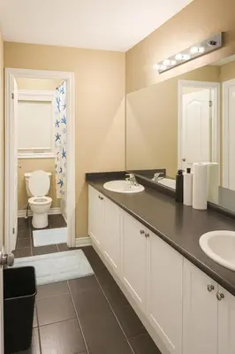 a bathroom with two sinks and a toilet at Spacious Brampton 4BR Upper Home in Brampton