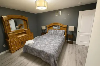 a bedroom with a bed and a dresser and a mirror at Spacious Brampton 4BR Upper Home in Brampton