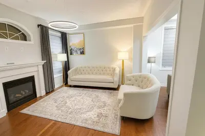 a living room with two white chairs and a fireplace at Spacious Brampton 4BR Upper Home in Brampton