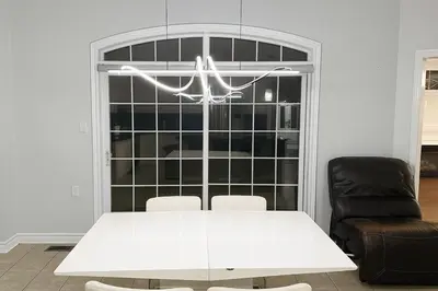 a white table and chairs in a room with a window at Spacious Brampton 4BR Upper Home in Brampton