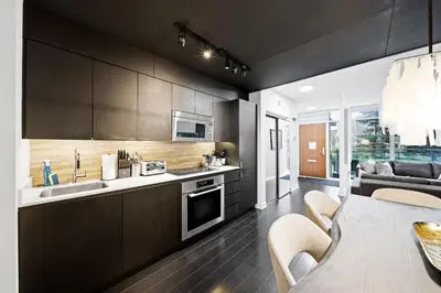 a kitchen with brown cabinets and a dining room at Luxury 4BR Home Sleeps 14 with Parking in Toronto