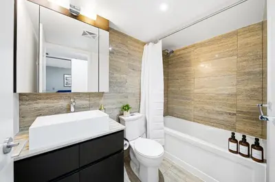 a bathroom with a sink and a toilet and a tub at Luxury 4BR Home Sleeps 14 with Parking in Toronto