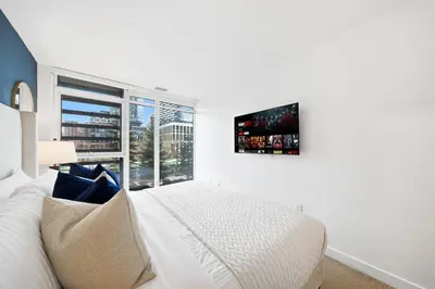 a bedroom with a white bed and a large window at Luxury 4BR Home Sleeps 14 with Parking in Toronto