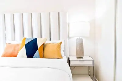 a white bedroom with a bed and a side table at Spacious 3-BDR Home with Incredible View with parking in Toronto