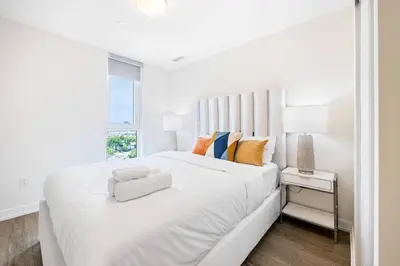a white bedroom with a large bed and a window at Spacious 3-BDR Home with Incredible View with parking in Toronto