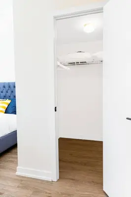 a bedroom with white walls and a bed and a mirror at Spacious 3-BDR Home with Incredible View with parking in Toronto