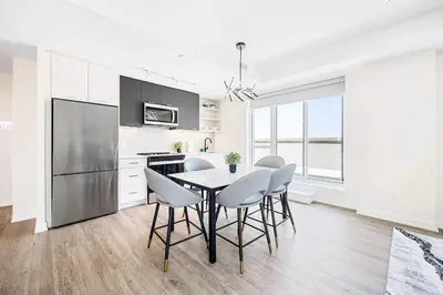 a kitchen with a table and chairs and a refrigerator at Spacious 3-BDR Home with Incredible View with parking in Toronto