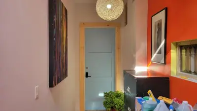 a hallway with an orange wall and a white door at Unique Above Garage Loft in Toronto