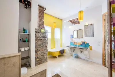 a bathroom with a yellow tub and a sink at Unique Above Garage Loft in Toronto