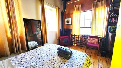 a bedroom with a bed and a chair and a window at Unique Above Garage Loft in Toronto