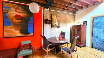 a dining room with a table and chairs and a painting at Unique Above Garage Loft in Toronto