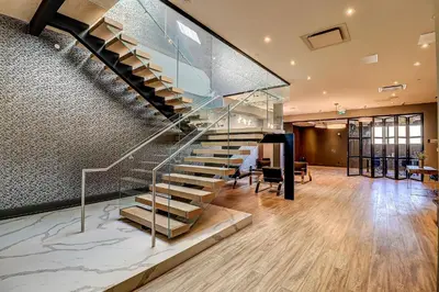 a staircase in a building with a glass railing at Dream Suites Near YYZ Airport in Mississauga