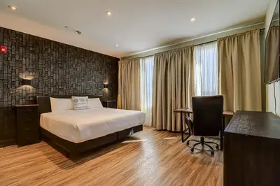 a hotel room with a bed and a desk and a television at Dream Suites Near YYZ Airport in Mississauga