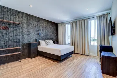 a bedroom with a bed and a television in it at Dream Suites Near YYZ Airport in Mississauga