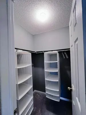 a closet with white shelves and a ceiling at Family Comfort Retreat in Brampton