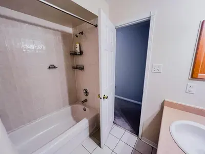 a white bathroom with a tub and a sink at Family Comfort Retreat in Brampton