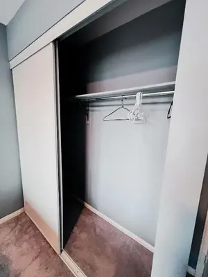 a walk in closet with a sliding glass door at Family Comfort Retreat in Brampton