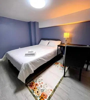 a bedroom with a bed and a desk with a lamp at Quiet King Bedroom near DT Toronto in Toronto