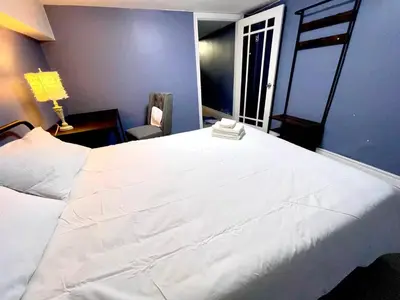a bedroom with a large white bed and a chair at Quiet King Bedroom near DT Toronto in Toronto