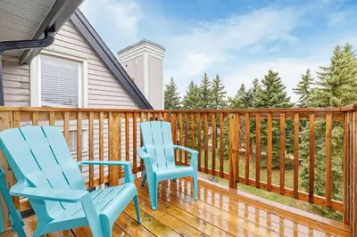 two blue chairs on the deck of a house at 109 North Creek in Blue Mountains