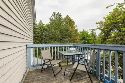 a patio with a table and chairs on a deck at 109 North Creek in Blue Mountains